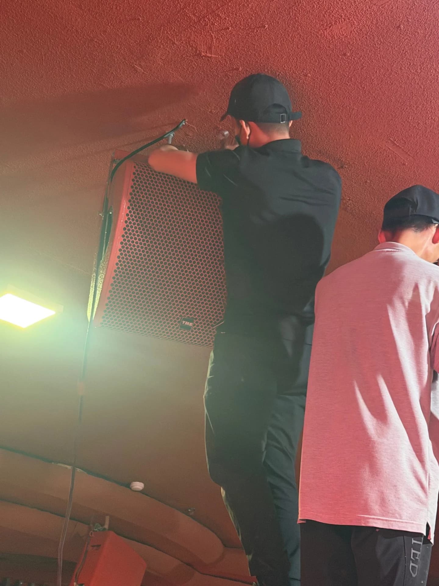 Kỹ thuật viên Tony Lab Audio lắp loa Monitor YME MC 14 trên tường tại Amara Club.
