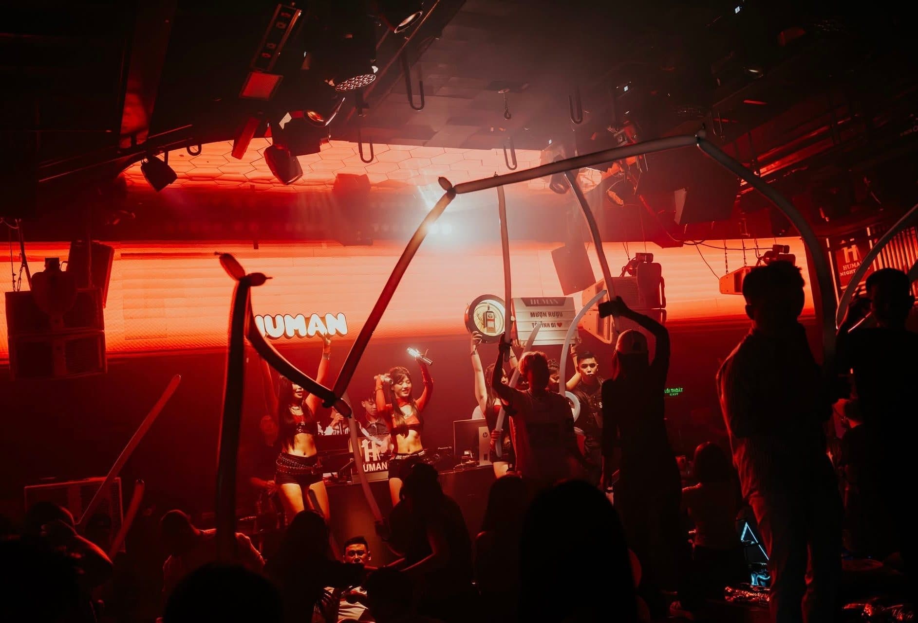 Vũ đoàn biểu diễn trên sân khấu Human Lounge với bảng hiệu HUMAN phía sau và khách vây quanh.