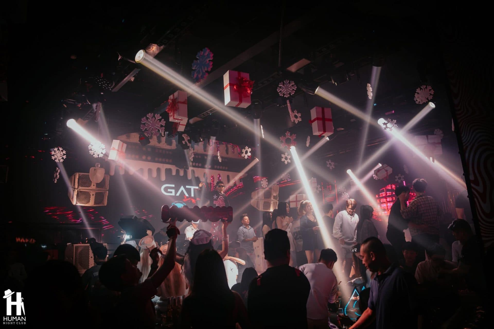 Sân khấu Human Lounge đang hoạt động về đêm với banner GAT, đông khách và ánh sáng sân khấu rực rỡ hai bên dàn loa Main PA.