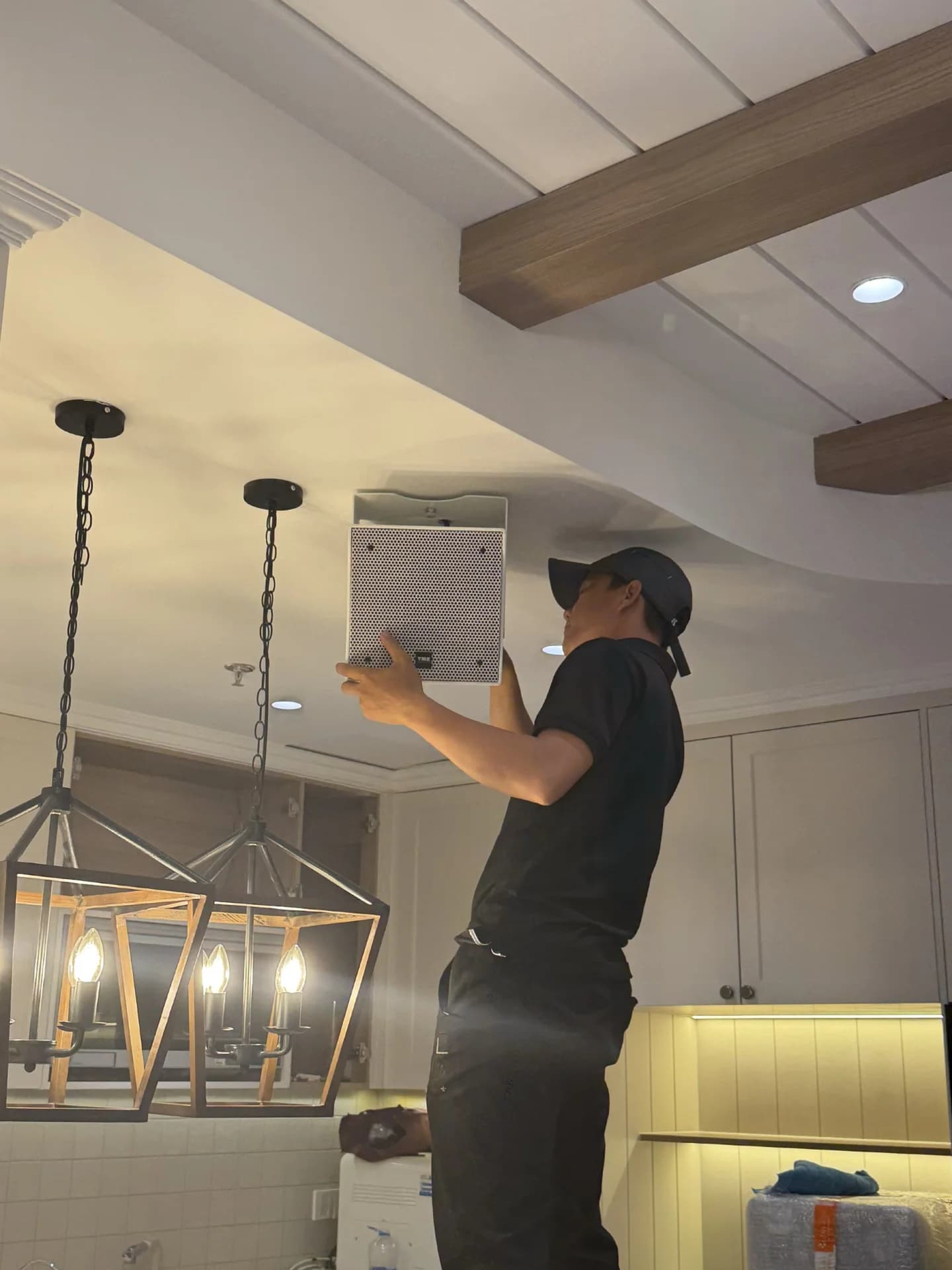 Kỹ thuật viên Tony Lab Audio kiểm tra kết nối và cân chỉnh góc nghiêng loa treo trần tại căn hộ chị Mai.