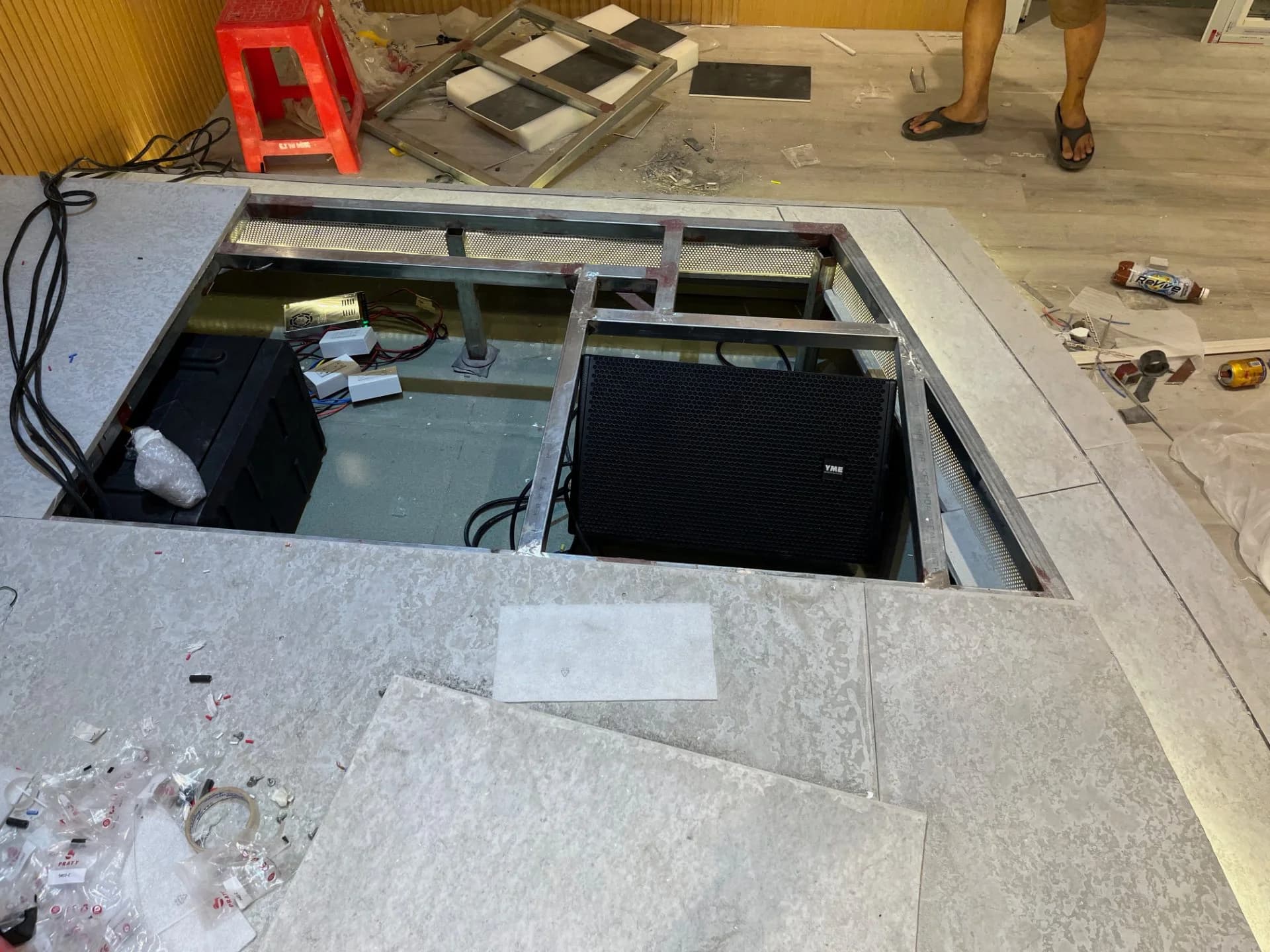 Loa Floor Monitor YME giấu dưới sàn sân khấu Giáo Xứ Võ Dõng trong quá trình thi công, mặt trước che bằng tấm gỗ tiêu âm.