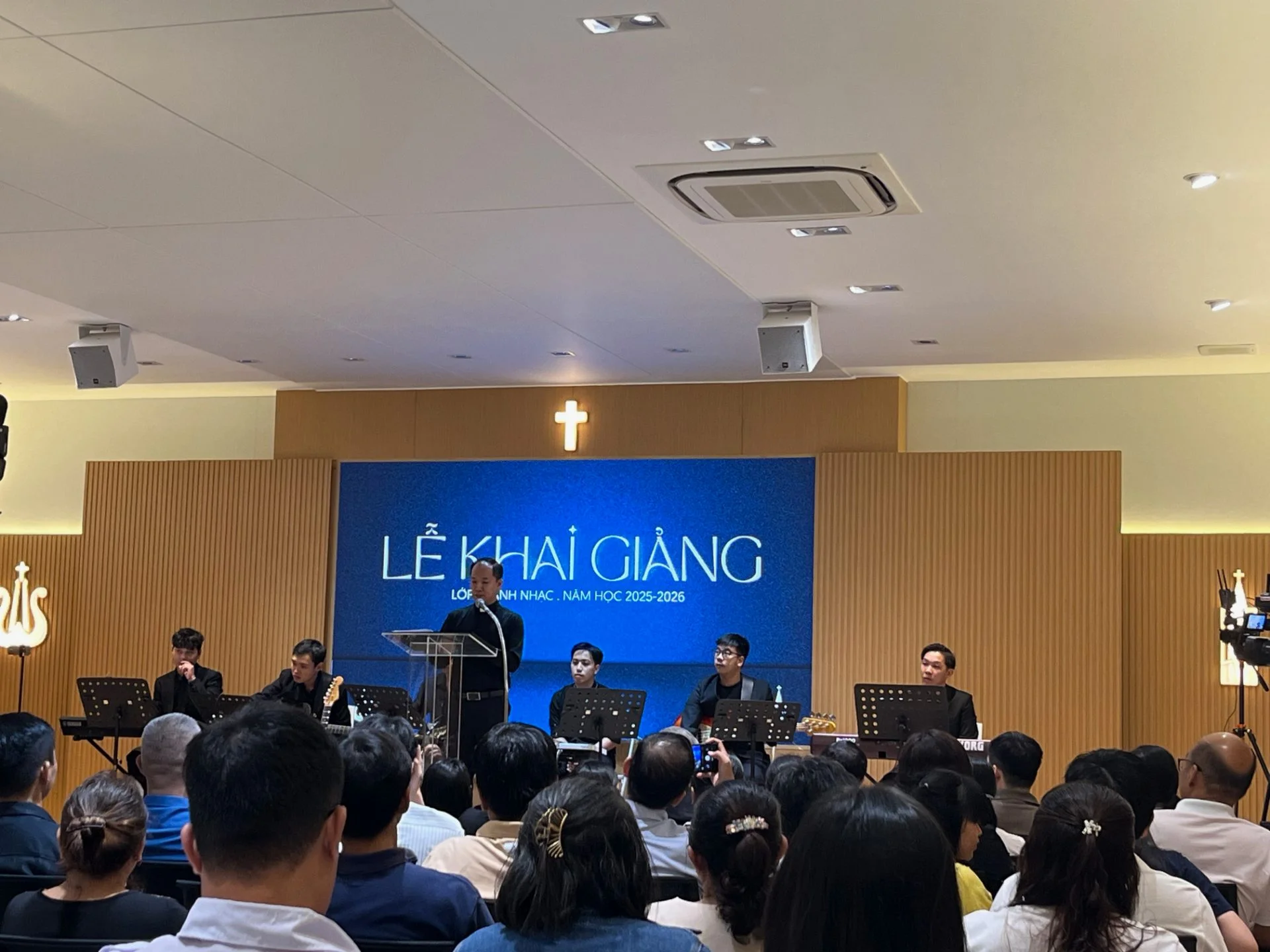 Cha Đaminh Nguyễn Thứ Trưởng giảng lễ khai giảng lớp Thánh Nhạc trước giáo dân tại phòng đa năng Giáo Xứ Võ Dõng, với hệ thống loa YME lắp trần và micro không dây.