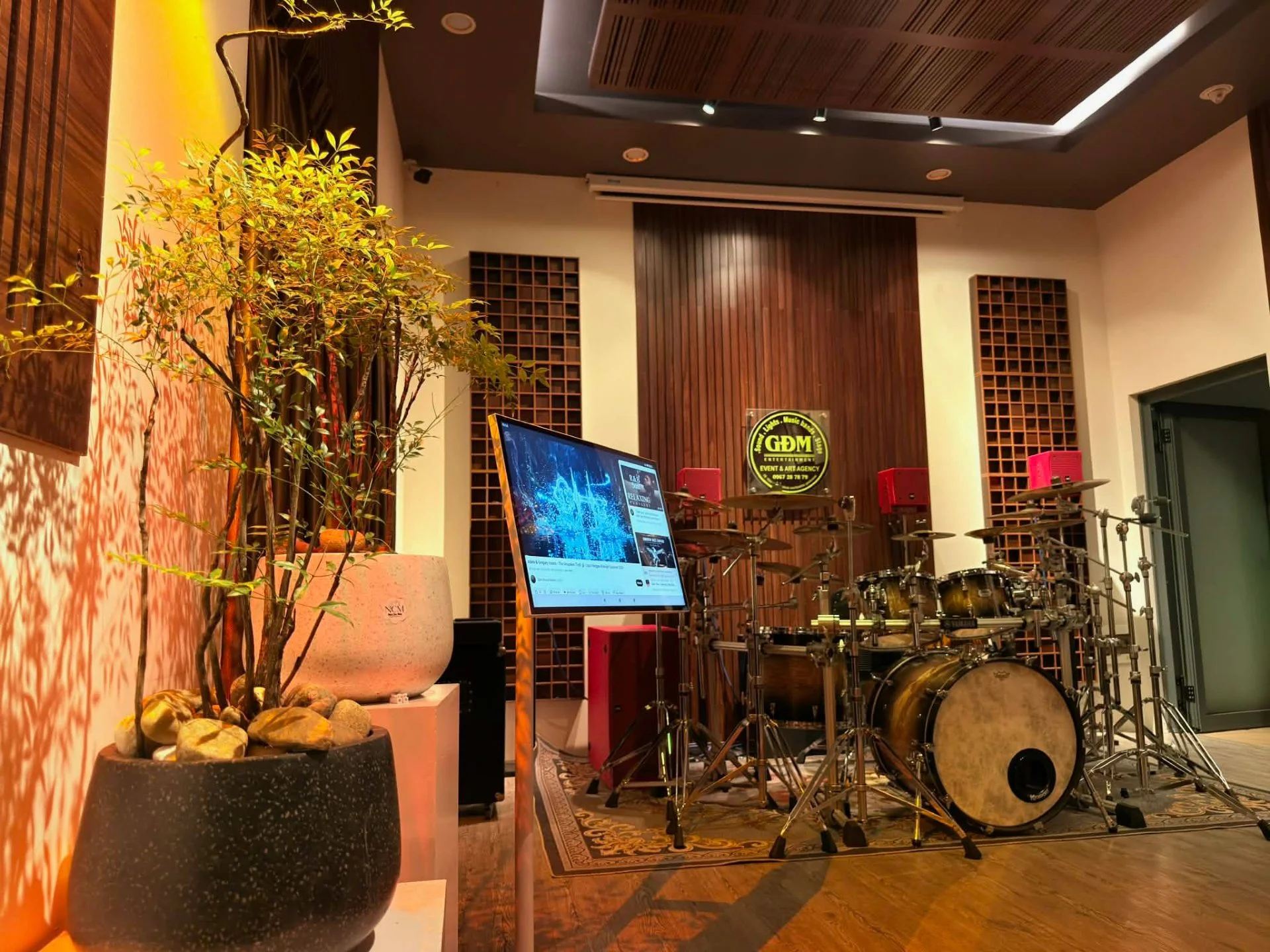 Phòng nghe nhạc gia đình với bộ trống Yamaha, loa YME Audiotechnik CS được đặt gắn tường và vách gỗ tiêu âm phía sau.